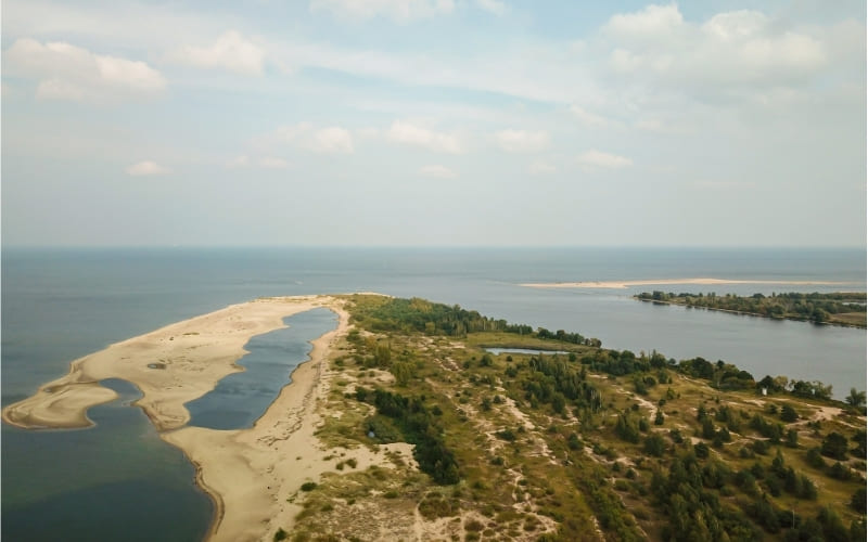 Lotniczy widok na ujście Wisły do Bałtyku, piaszczystą plażę, wydmy i tereny przyrodnicze Wyspy Sobieszewskiej w Gdańsku